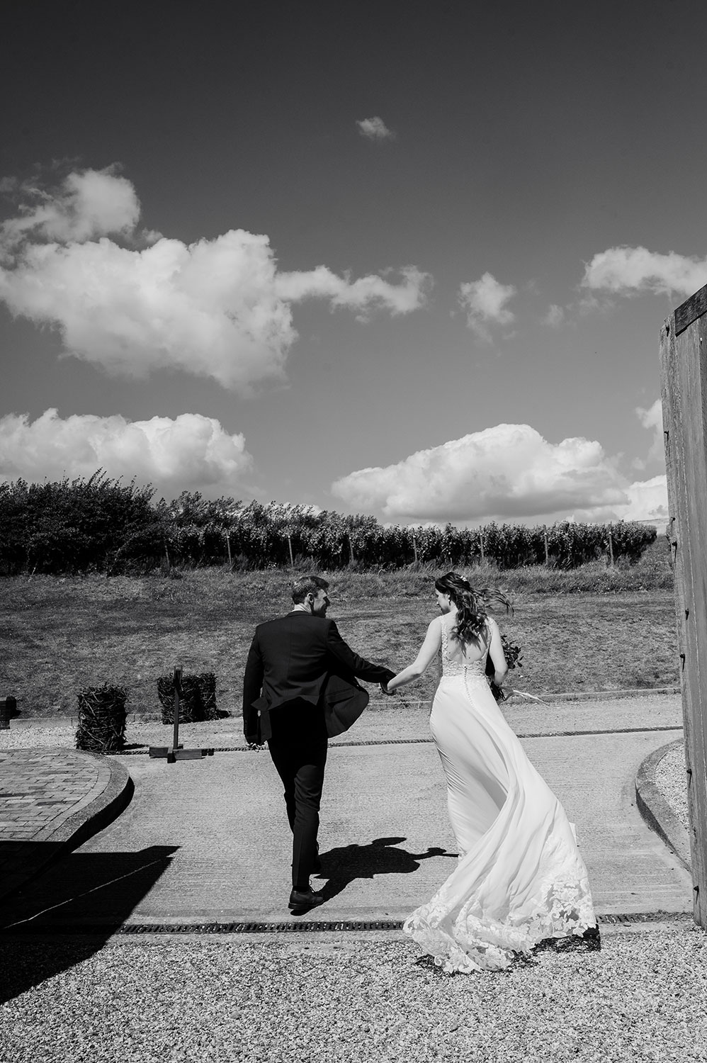 Brighton wedding photgraphy. Bride and groom walking away from the camera photographed in Black and white 
