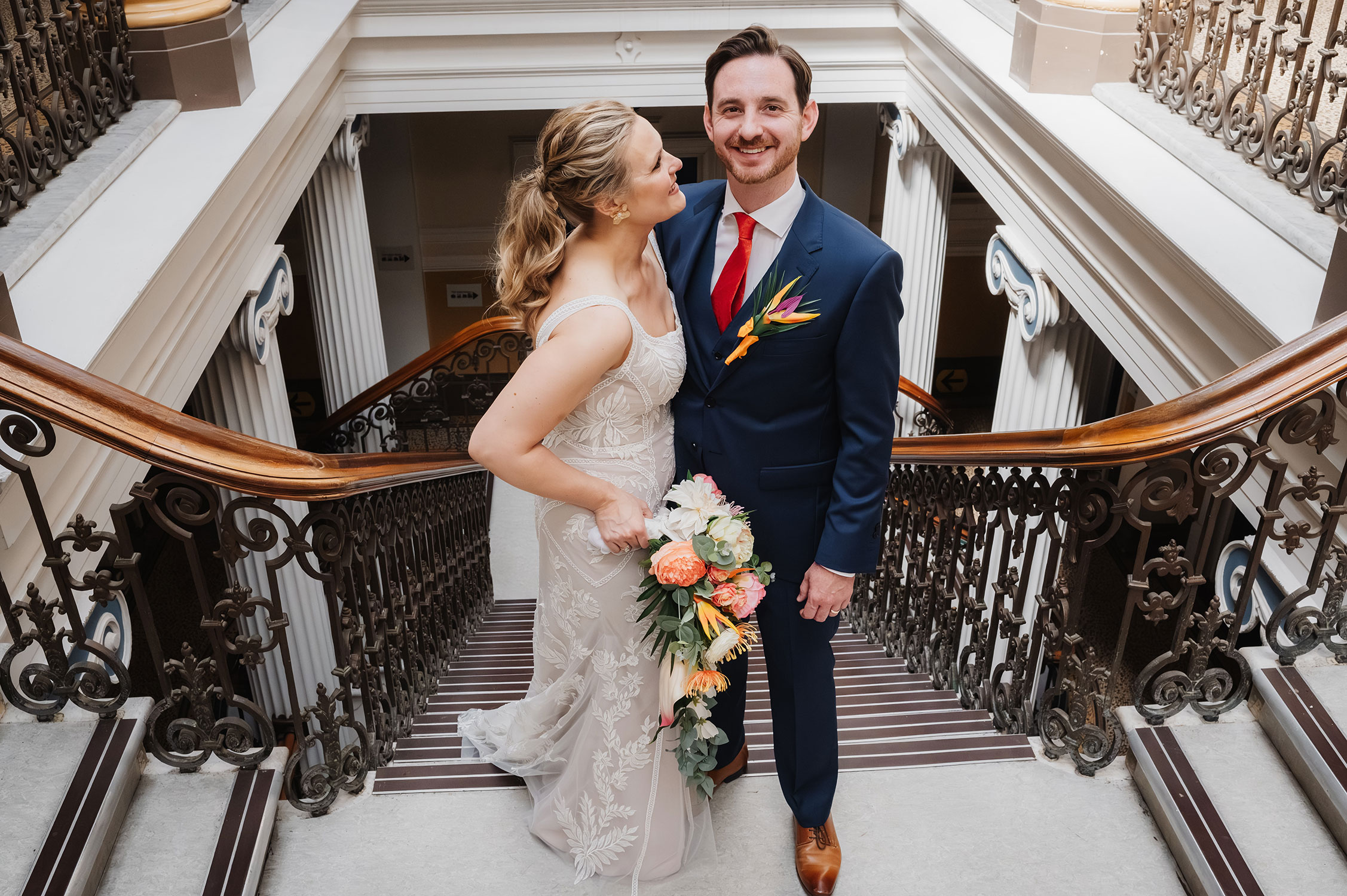 Bride and groom on the stairs inside of Brighton Town Hall. Photographed by Jacqui mcsweeney
